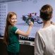 two kids standing by an interactive board